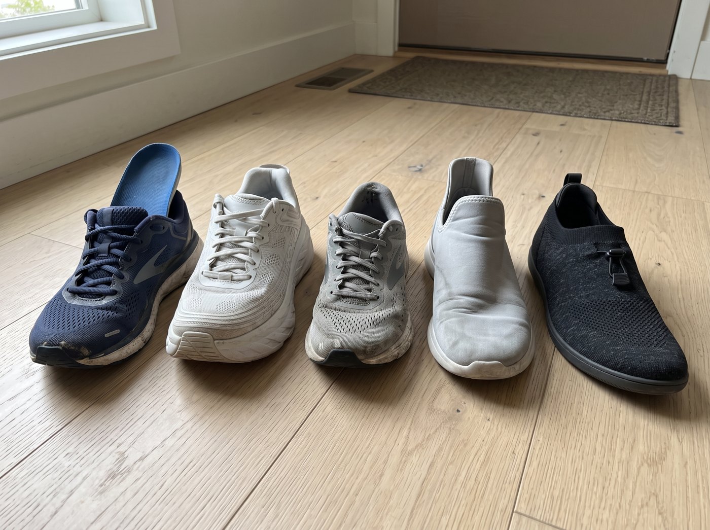 Five shoes in a row by a front door